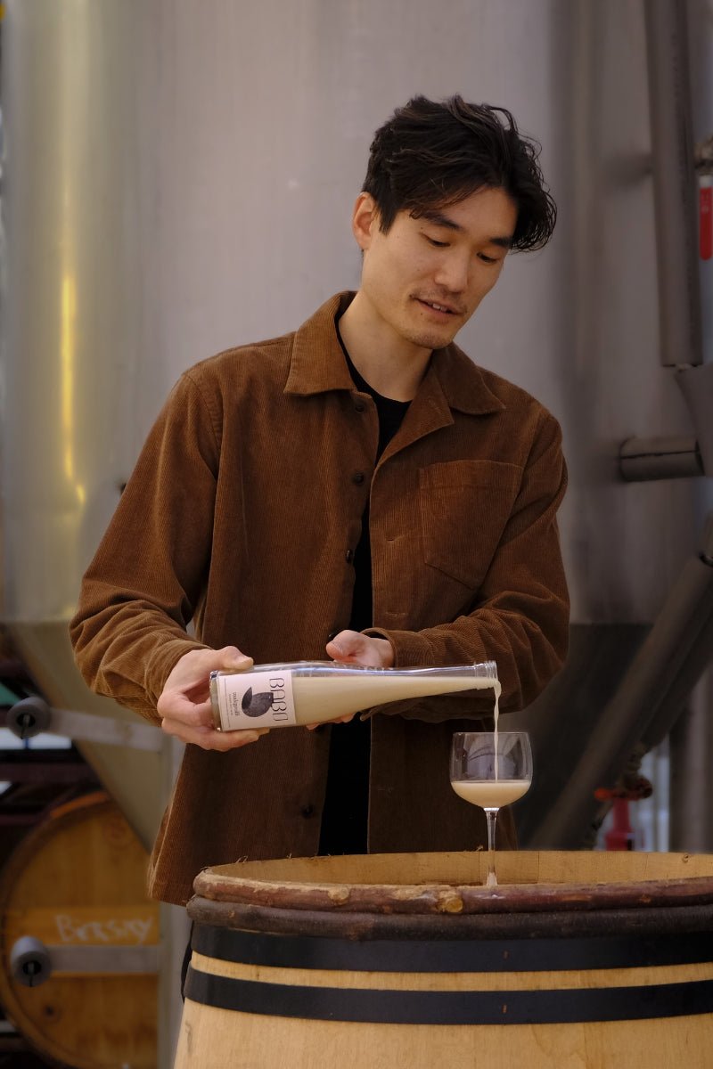 Pouring Babo Makgeolli, traditional Korean rice wine, into a glass.