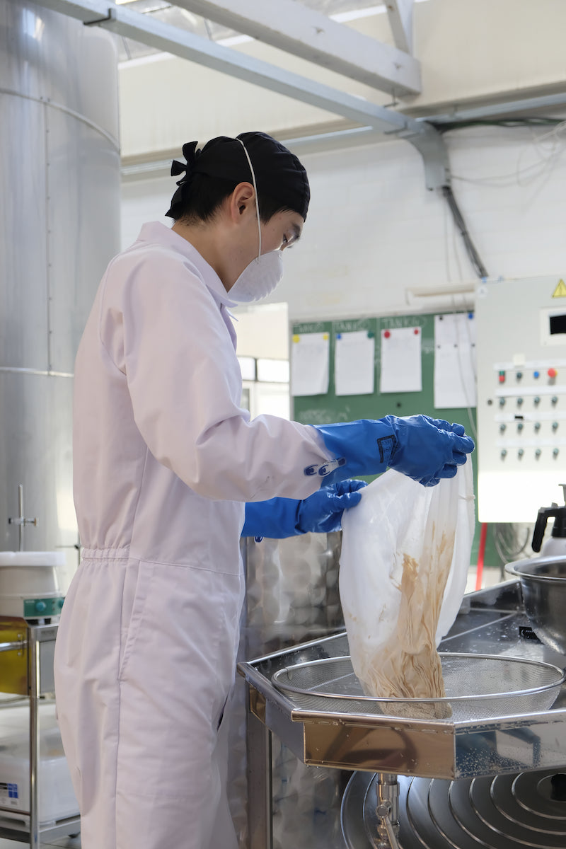 Tim filtering makgeolli during the brewing process.